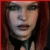 Pixelated close-up of a person with long dark hair, neutral expression, and light skin tone against a red-brown background.