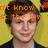 A pixelated image of a person with brown hair and a black jacket over a light blue shirt against a yellow background with orange text partially visible.