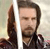 A pixelated image shows a person with dark hair and a beard holding a white lightsaber-like object, with a blurred background.
