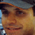 Two side-by-side pixelated images of a person wearing a dark cap with an orange brim, showing different facial expressions and slight head angles.
