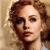 Pixelated close-up of a person with curly brown hair against a light brown background, wearing a light-colored top.