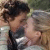 A pixelated static image shows two people in a close embrace, one with dark hair and the other with lighter hair, both facing each other.