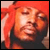 Pixelated static image of a person with red hair and dark clothing against a solid red background, rendered in low-resolution 256x256 pixels.
