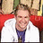 Pixelated static image of a person with light brown hair wearing white and red clothing against a blurred background.
