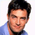 A pixelated image of a person with dark hair wearing a light blue shirt against a white background, next to green text on a dark green background.