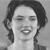A grayscale pixelated portrait of a person with shoulder-length hair, closed eyes, and a slightly open mouth showing teeth, set against a plain background.