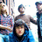 Pixelated image of four people in a group pose with a black background containing white text.