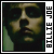 Pixelated static image of a person's face with vertical text reading "BILLIE JOE" on the right side, set against dark background with green and brown tones.
