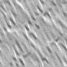 Static grayscale image of diagonal metallic ridges with alternating light and dark bands, no visible text or distinct subjects.