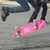 A static image shows a person lying on the ground wearing dark pants and shoes, with a pink blanket or fabric covering their lower body.