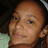 Pixelated close-up of a person's face with light brown skin tone, dark eyes, and short hair against a black background.