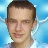 A pixelated close-up of a person's face with short brown hair against a light blue background featuring white wing-like shapes.