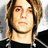 Pixelated portrait of a person with light brown hair and a black shirt, accompanied by red text labels on a black background.