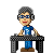 Pixelated character with gray hair and blue glasses stands behind a black desk, wearing a blue shirt with white question mark.