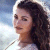 Static pixelated image of a person with curly dark hair wearing a white top against a light blue background, rendered in low-resolution 256x256 pixels.