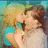 Two figures in a close embrace, one with light hair in a blue top, the other with dark hair in a light top, against a blurred green and blue background.