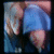 A person in a blue shirt and dark pants holds their head with both hands, showing slight movement across frames.