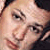 Pixelated close-up of two faces in profile view, one with light skin and dark hair, the other with darker skin and dark hair, both facing left with neutral expressions.
