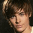 Pixelated close-up of a person with brown hair and light skin, dark background.