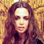 Pixelated portrait of a person with long brown hair against a warm-toned, blurred background with yellow and brown hues.
