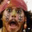 A pixelated close-up of a person with light skin, brown hair under a red headwrap, and dark clothing; the mouth is open in an expression.