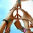 A person in a bikini top with pink straps and green wristbands forms a peace sign against a light blue background.
