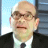 Static 48x48 pixel icon showing a close-up of an older man with light skin, glasses, and a black suit against a blue-gray background.