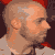 Pixelated profile of a light-skinned person with short hair against dark background, next to red with black text "THERE & BACK AGAIN"