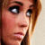 Pixelated close-up of a person's face with light brown hair, dark eyes, and a neutral expression against a light background.