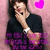 A person in a black and purple gradient shirt with a white wristband poses with hand near mouth against pink background with pink heart symbols.