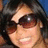 A pixelated image of a person with dark hair and sunglasses on the left, next to blue text reading "she is the reason i SMILE <3" on a purple background.