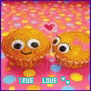 Animated pixel art of two orange muffin-shaped characters with large eyes and pink bows, standing on a pink dotted background with small hearts.