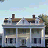 A pixelated image showing a two-story house with chimneys on the left and text "he promised" in black pixel font on the right against a light blue background.