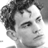 Black-and-white pixelated static image of a person's face with curly hair, visible in 48x48 icon format on white background.