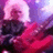 Pixelated image with pink and purple hues showing a figure in dark clothing against a bright background.
