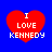 Four red heart shapes on a blue background, each containing white text reading "I LOVE KENNEDY" in pixelated font.