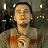 A pixelated figure with short dark hair wears a light-colored sleeveless top with orange accents, standing against a dark background with scattered white light spots.