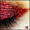 A pixelated close-up of a red and purple striped fabric with a black fringe, set against a light beige background and featuring a small red heart symbol in the bottom right corner.