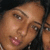 Pixelated close-up of two people's faces in profile view, one with light skin and visible teeth, the other partially obscured.