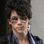Pixelated portrait of a person with dark curly hair and glasses, next to cyan text on black background reading 'nick jona: love: holly'.
