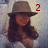 A person wearing a gray fedora and white top with long brown hair, shown in four with changing red text overlays