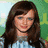 Two side-by-side pixelated images of a woman with long brown hair, one showing her looking down and the other smiling directly at viewer.