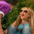 Two women with long hair and sunglasses appear in a split-screen view, one wearing blue clothing on the left and another in light-colored top on the right.