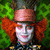 A pixelated image of a character with orange hair and white face paint, surrounded by green foliage, with green text blocks and heart symbols on a black background.