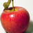 A pixelated red apple with a green stem and leaf, showing light reflection on its surface against a plain background.