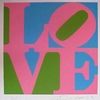 A static pixelated graphic with overlapping pink, blue, and green shapes forming stylized letters against a white border.