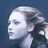 Pixelated static image of a person's profile with light hair against dark blue background, rendered in low-resolution 256x256 pixels.