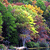 Pixelated abstract composition of green, yellow, and brown tones with scattered dark and light patches, no discernible subjects or text.