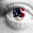Pixelated close-up of a character's eye with red and blue highlights on the iris, set against a blurred grayscale background.