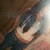 A pixelated image of a person with long brown hair wearing a dark top, partially visible against a brown background.